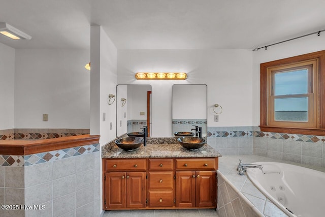 bathroom with double vanity, a sink, and a jetted tub
