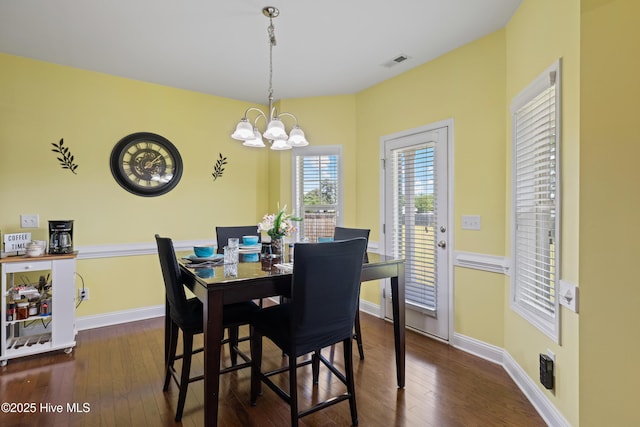 dining area with a chandelier, dark wood-style floors, and baseboards