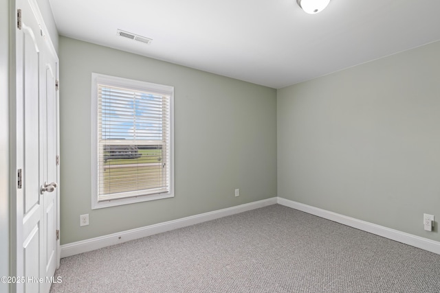 spare room featuring baseboards and carpet floors