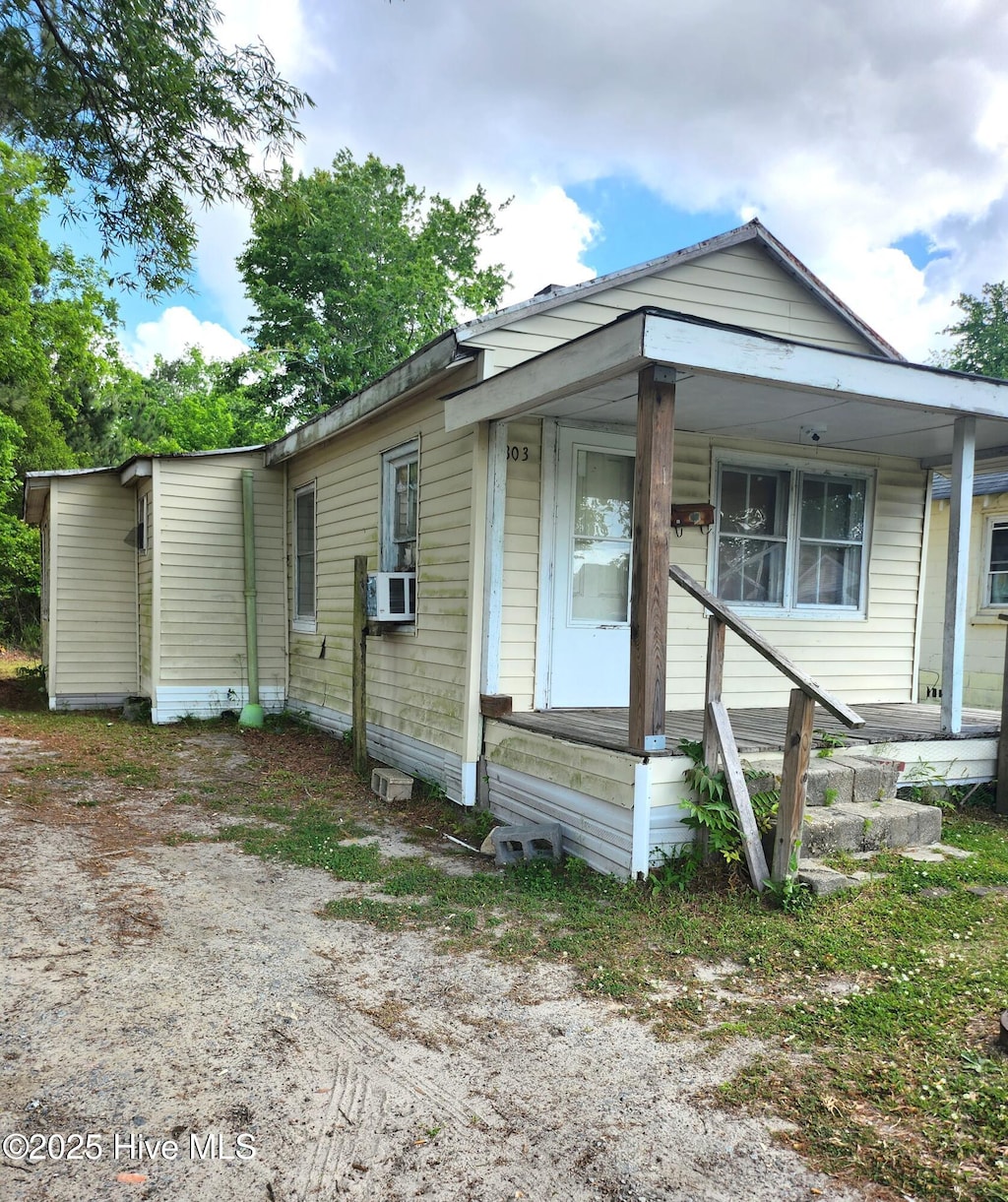 view of front of house with cooling unit and a porch