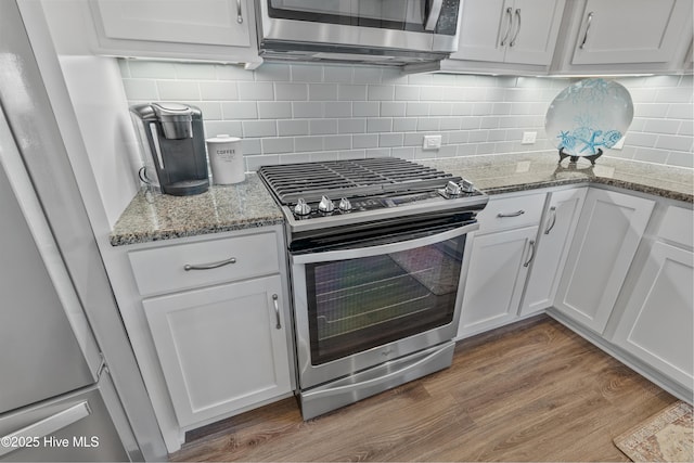 2465 Meridian Rd NE, Leland, NC 28451 - kitchen featuring appliances with stainless steel finishes, backsplash, white cabinetry, and wood finished floors