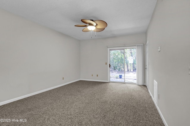 carpeted empty room with a ceiling fan, baseboards, and a textured ceiling