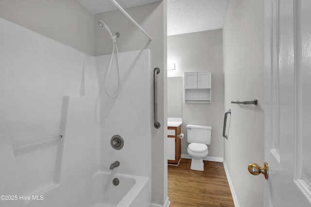 full bathroom with wood finished floors, shower / tub combination, toilet, vanity, and baseboards