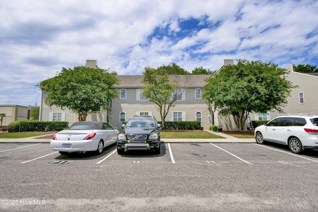 view of front of property featuring uncovered parking and a chimney