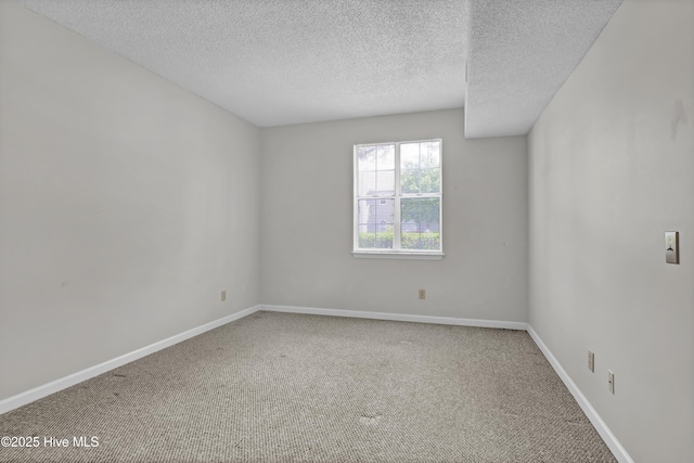 unfurnished room featuring carpet, baseboards, and a textured ceiling