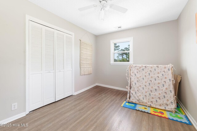 rec room featuring a ceiling fan, baseboards, visible vents, and wood finished floors