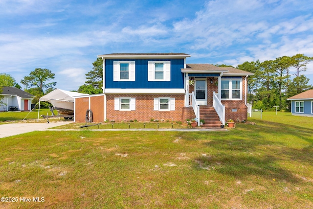 split level home with brick siding, a front lawn, an attached carport, and concrete driveway