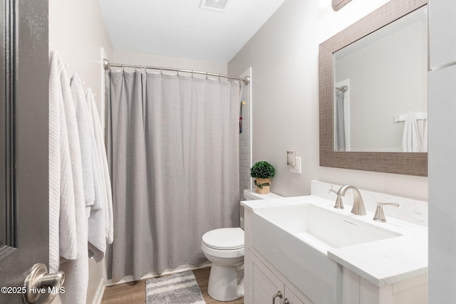 full bathroom featuring toilet, a shower with curtain, wood finished floors, and vanity