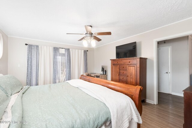 bedroom with crown molding, baseboards, a ceiling fan, and wood finished floors
