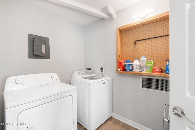 laundry room with baseboards, laundry area, washing machine and dryer, and wood finished floors