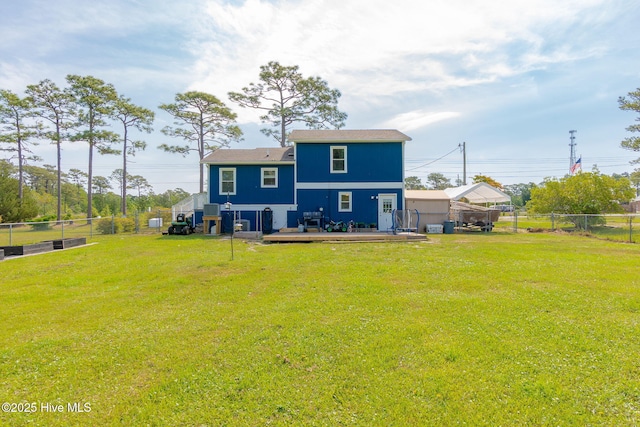 rear view of house featuring a fenced backyard, a yard, and a deck