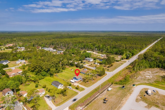 birds eye view of property featuring a forest view