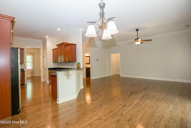 4 Cordelia Way, Vass, NC 28394 - kitchen featuring dark countertops, freestanding refrigerator, ceiling fan with notable chandelier, a peninsula, and open floor plan