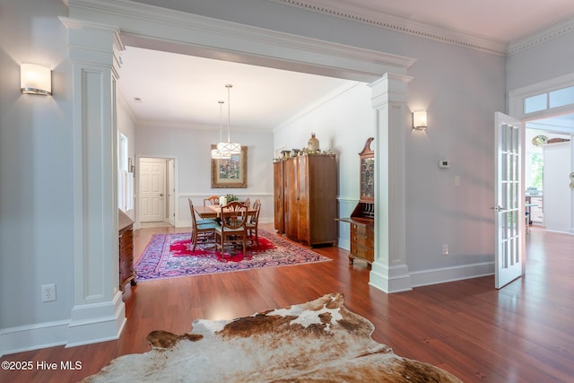dining area with baseboards, decorative columns, and wood finished floors