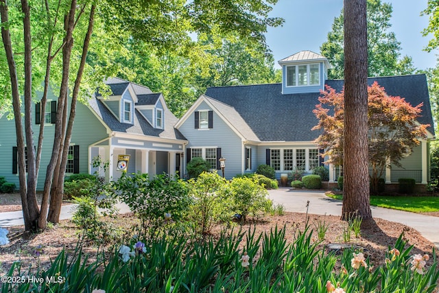 cape cod home with a porch and driveway