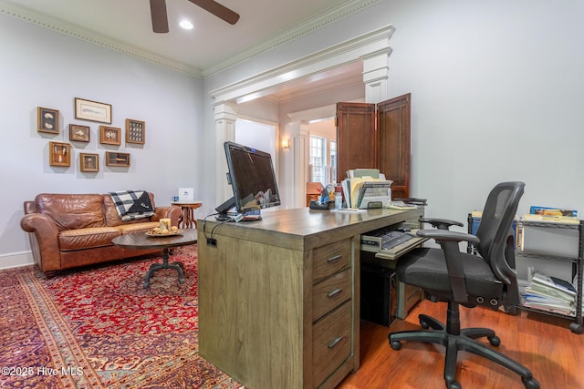 home office with crown molding, a ceiling fan, decorative columns, and wood finished floors