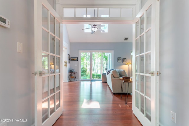 corridor featuring high vaulted ceiling, french doors, wood finished floors, and visible vents