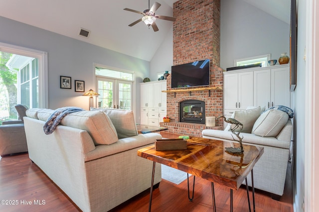 living area with a ceiling fan, high vaulted ceiling, visible vents, and a wealth of natural light