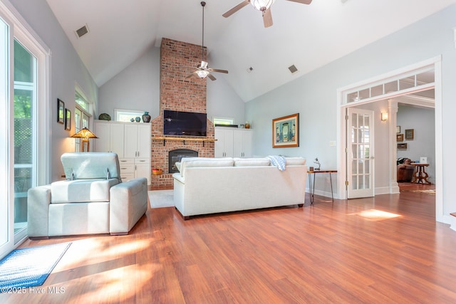 living room with ceiling fan, wood finished floors, and visible vents