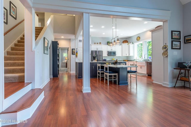 dining area with an inviting chandelier, stairs, baseboards, dark wood-type flooring, and recessed lighting