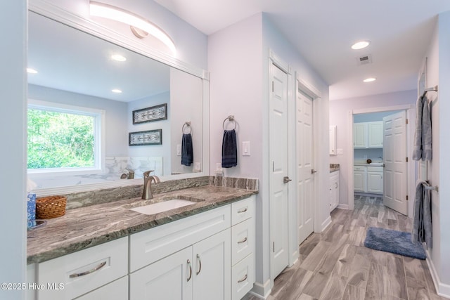 full bathroom featuring vanity, baseboards, recessed lighting, and visible vents