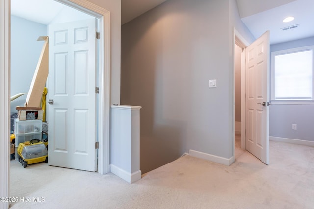 corridor featuring carpet floors, baseboards, and visible vents