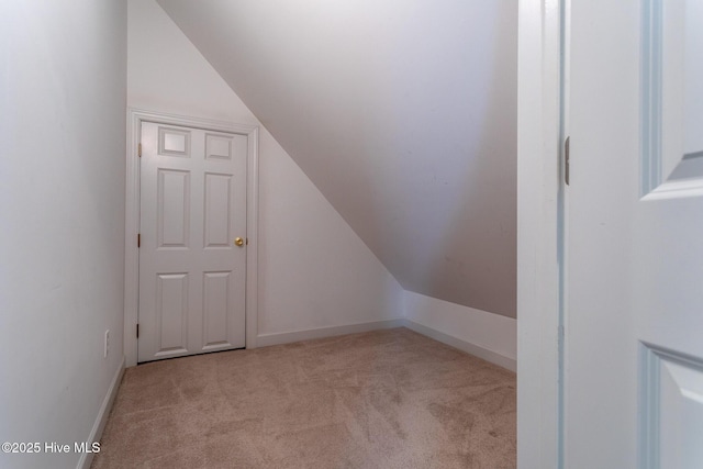 additional living space with carpet floors, baseboards, and vaulted ceiling
