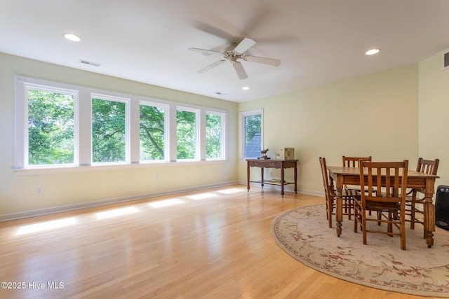 dining room with baseboards, a ceiling fan, light wood-style flooring, and a wealth of natural light