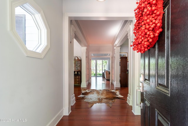 entrance foyer featuring crown molding, baseboards, ornate columns, and wood finished floors