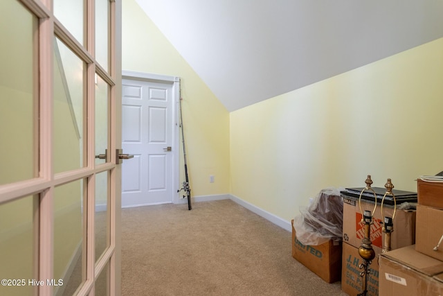 additional living space featuring light colored carpet, baseboards, and lofted ceiling
