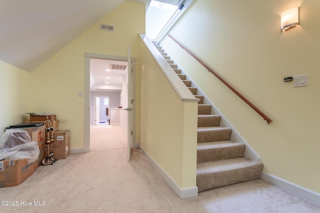 stairway featuring baseboards, carpet, lofted ceiling, and visible vents
