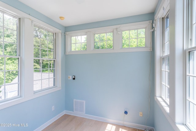 interior space featuring baseboards, visible vents, and light wood finished floors