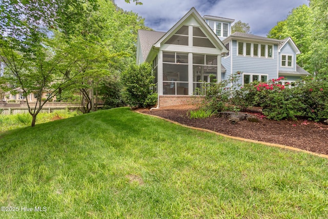 back of property with a yard and a sunroom
