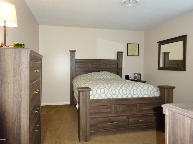 bedroom with baseboards and dark colored carpet