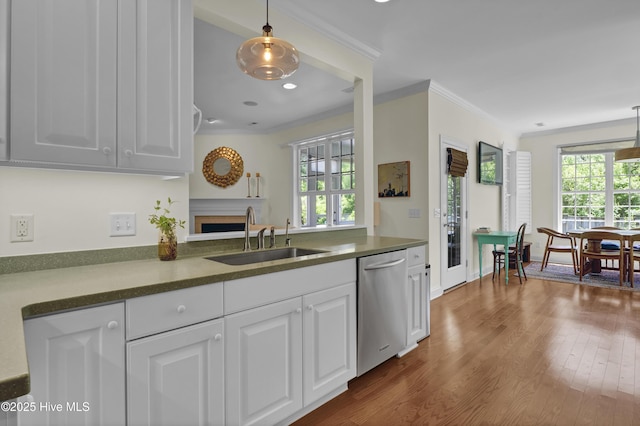 745 Royal Bonnet Dr, Wilmington, NC 28405 - kitchen with white cabinets, crown molding, a sink, a fireplace, and dishwasher