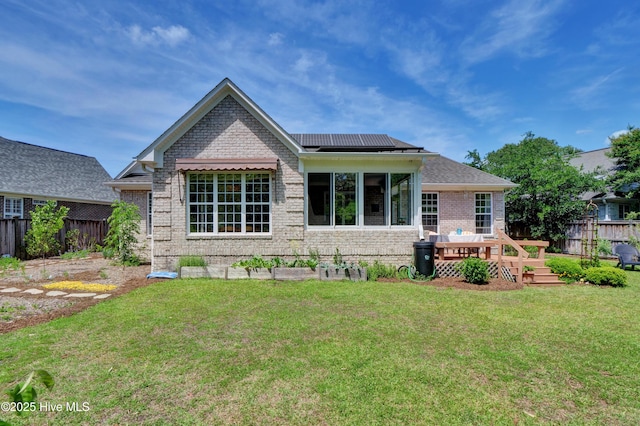 745 Royal Bonnet Dr, Wilmington, NC 28405 - back of property with fence, a wooden deck, brick siding, a yard, and solar panels