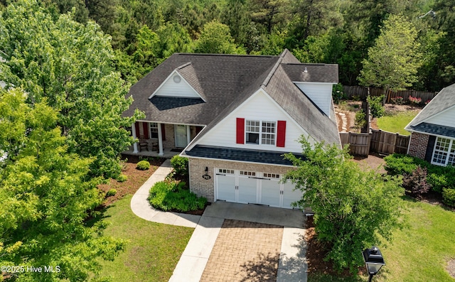 745 Royal Bonnet Dr, Wilmington, NC 28405 - view of front of house featuring a garage, a front lawn, fence, a view of trees, and driveway