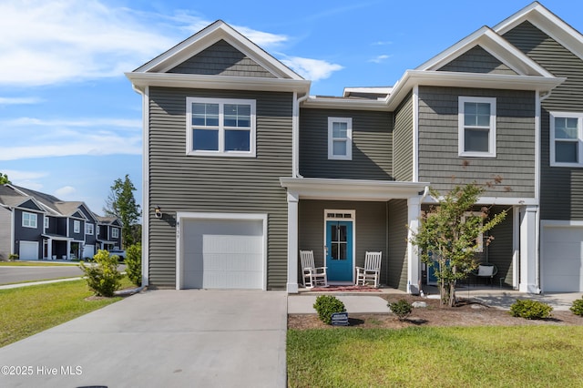 4739 Oyster Reef, Wilmington, NC 28405 - townhome / multi-family property featuring covered porch, driveway, a front yard, and a garage