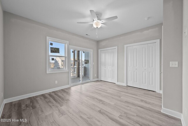 146 Sea Gull Ln, North Topsail Beach, NC 28460 - unfurnished bedroom with two closets, access to exterior, baseboards, light wood-type flooring, and a ceiling fan