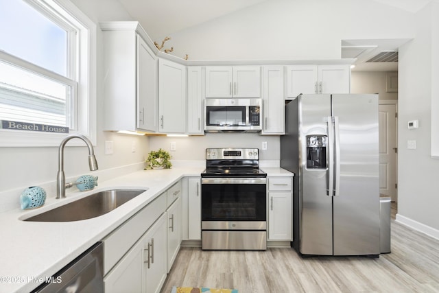 146 Sea Gull Ln, North Topsail Beach, NC 28460 - kitchen with white cabinets, stainless steel appliances, a sink, and light wood finished floors
