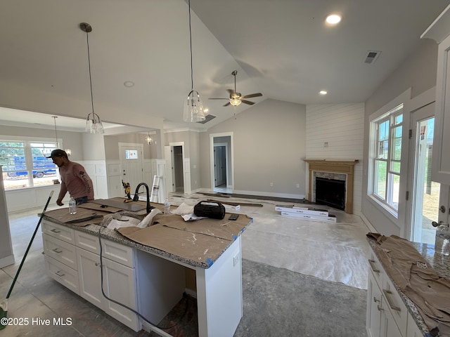 107 Tee Dr, Selma, NC 27576 - kitchen with a high end fireplace, ceiling fan, white cabinets, stone countertops, and vaulted ceiling