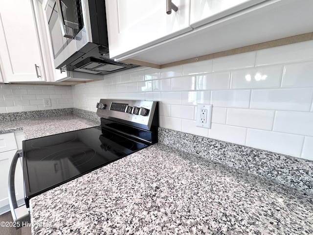 kitchen with white cabinets, backsplash, appliances with stainless steel finishes, and light stone counters