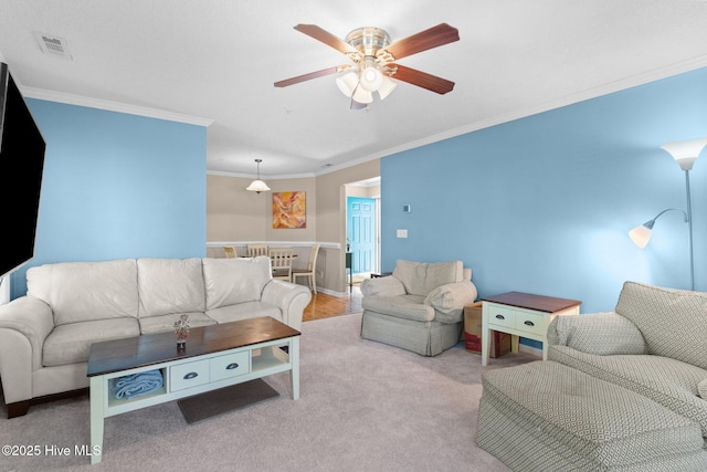 living room with crown molding, a ceiling fan, carpet flooring, and visible vents