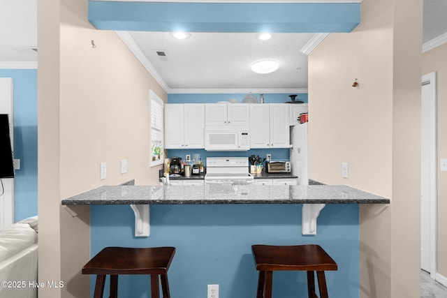 kitchen with crown molding, dark stone countertops, a peninsula, and white appliances