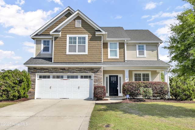 craftsman house with a garage, a front lawn, stone siding, roof with shingles, and driveway
