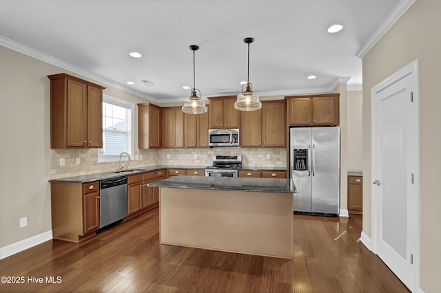 kitchen with appliances with stainless steel finishes, brown cabinetry, ornamental molding, and dark wood-type flooring