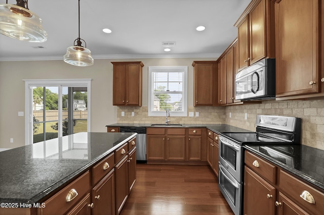 kitchen featuring a sink, stainless steel appliances, backsplash, visible vents, and ornamental molding