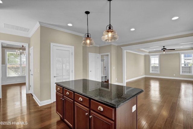 kitchen with baseboards, visible vents, and ornamental molding
