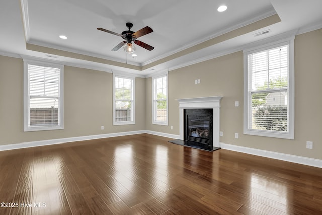 unfurnished living room featuring crown molding, a ceiling fan, a tray ceiling, and visible vents