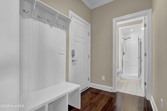 mudroom featuring baseboards, ornamental molding, and dark wood-type flooring